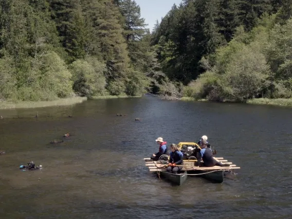 A lake in a forest with people on a boat