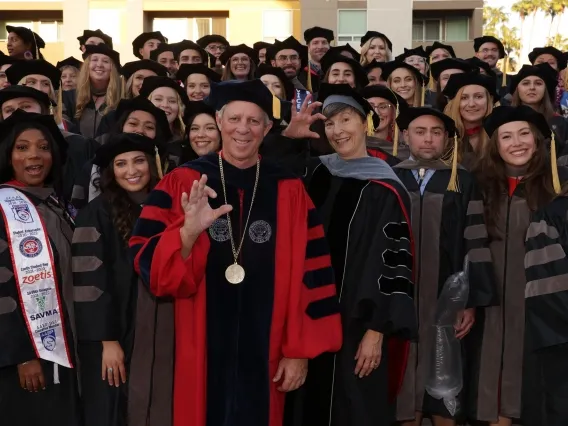 University of Arizona President Robert C. Robbins and College of Veterinary Medicine Dean Julie Funk pose with the college&#039;s first graduating class after the Aug. 24 Commencement