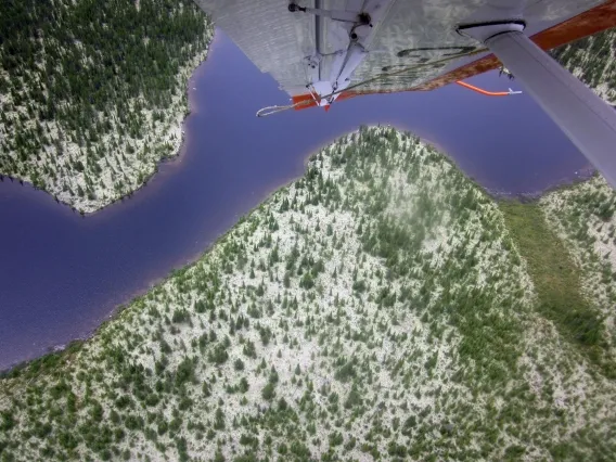 The view of a lake and landscape from the cockpit of a plane