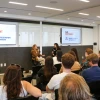 A group of University of Arizona alumni and guests sit in a modern conference room listening to a panel discussion hosted by Film Independent and the University of Arizona’s Film & Television Los Angeles program. Two women are seated at the front speaking into microphones, with dual screens behind them displaying the Film Independent and UArizona FTV LA logos.